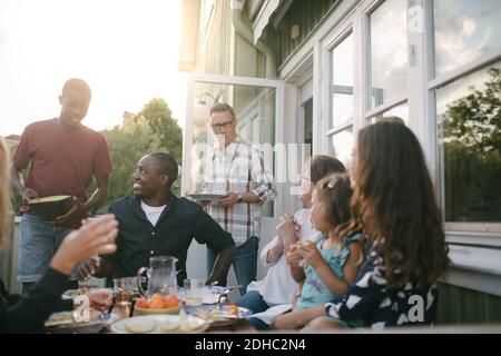 Buona famiglia multigenerazionale che gusterete il pranzo al portico Foto Stock