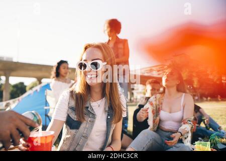 Immagine ritagliata dell'uomo che versa alcol a una donna sorridente a. festival Foto Stock