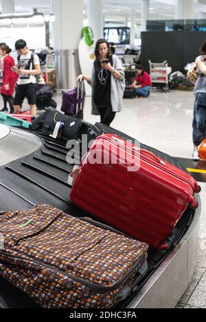 Nastro trasportatore Aeroporto Internazionale/Aeroporto di Hong Kong con persone nel distanza Foto Stock