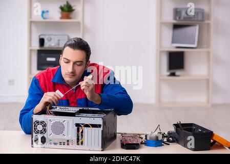 Giovane uomo riparatore che ripara il computer Foto Stock
