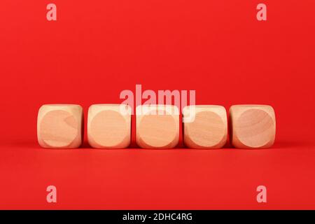 Primo piano cinque segni vuoti di cubo di legno su sfondo rosso con spazio di copia, vista frontale ad angolo basso Foto Stock