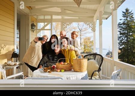 Amici felici maturi che posano per selfie del telefono delle cellule sul portico Foto Stock