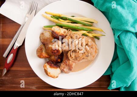 tritare il maiale con patate fritte, funghi e fagioli Foto Stock