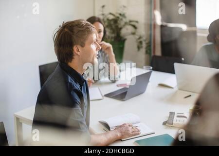 Imprenditore a discutere con i colleghi durante la riunione in ufficio Foto Stock