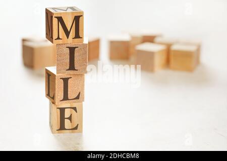 Quattro cubetti di legno disposti in pila con la parola MIGLIO (che significa il massimo impatto poco sforzo) su di loro, spazio per il testo / immagine in basso a destra angolo Foto Stock