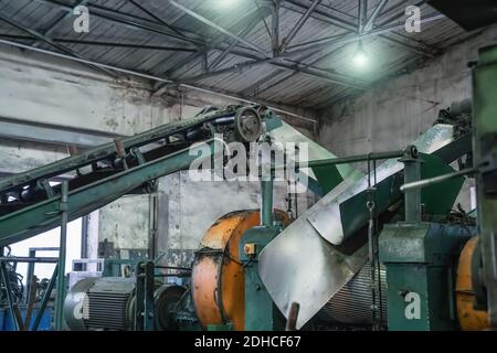 Fabbrica di riciclaggio della gomma, attrezzature industriali e linea di trasporto con pneumatici usati tagliati. Riciclaggio dei rifiuti. Foto Stock