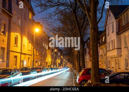 Strada residenziale, molti edifici di appartamenti in una zona residenziale, sera, illuminazione lanterna, Essen, NRW, Germania Foto Stock