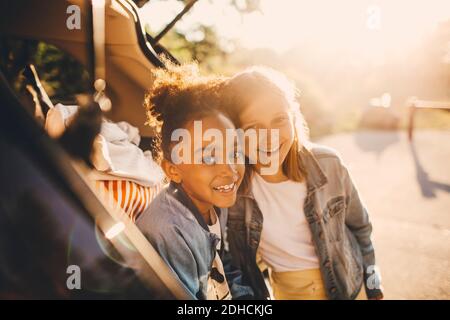Ritratto di ragazze multietniche sorridenti nel bagagliaio dell'auto durante il picnic Foto Stock