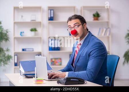 Divertente impiegato clown che lavora in ufficio Foto Stock