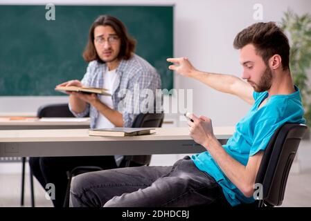 Due alunni maschi in concetto di bullismo in classe Foto Stock