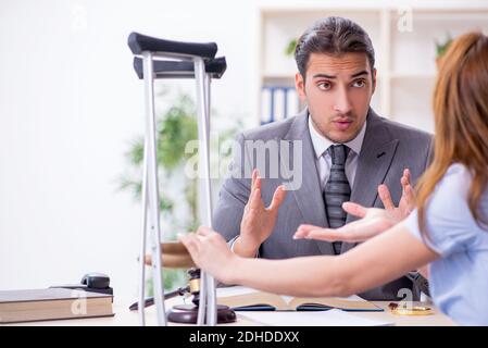 Giovane donna ferita e avvocato maschile in aula Foto Stock