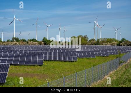 Pannelli solari con turbine eoliche nella parte posteriore visto in Germania Foto Stock