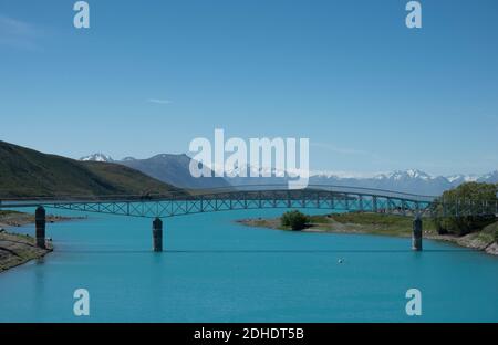 Ponte pedonale sul fiume Tekapo dai colori turchesi Foto Stock