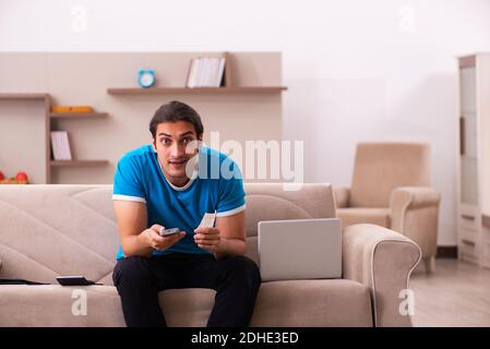 Sport scommessa addicted giovane uomo scommettendo a casa Foto Stock