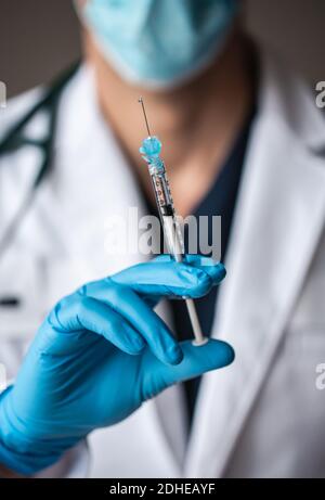 Primo piano del medico che tiene l'ago con il vaccino pronto per l'iniezione. Foto Stock