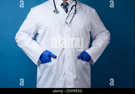 Medico in un cappotto bianco si trova su uno sfondo blu, l'uomo in una cravatta Foto Stock