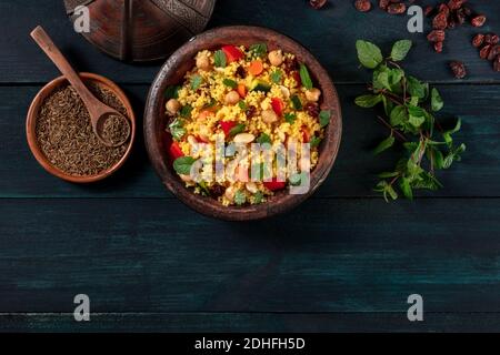 Couscous marocchino con ingredienti, sopra la testa piatta su uno sfondo scuro Foto Stock