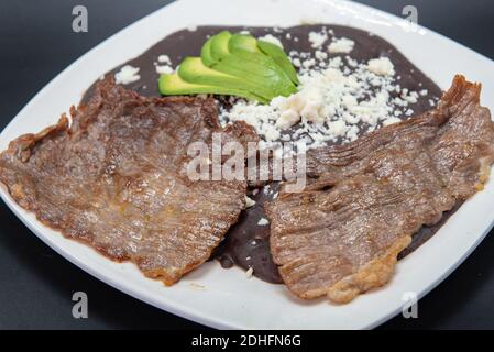 Carne asada perfettamente preparata sulla griglia con fagioli e avocado sulla parte superiore. Foto Stock