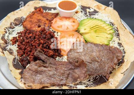 Piatto taco da condividere con la famiglia, tra cui carne di asada al carne, hamburger, pollo pollo e avocado e condimenti di pomodoro. Foto Stock