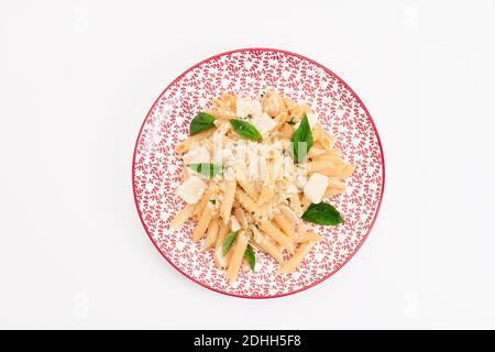 Vista dall'alto di un delizioso piatto con pasta, formaggio ed erbe cotte su uno sfondo chiaro. Concetto di cibo sano e pasta. Foto Stock