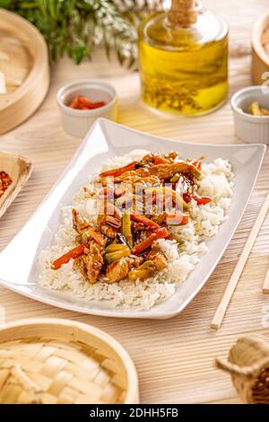 Mescolare il pollo fritto con le verdure guarnite con riso bollito bianco Foto Stock
