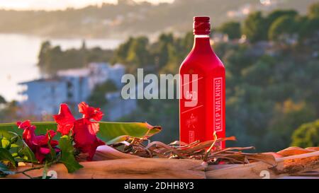 VOLOS, GRECIA - 30 novembre 2020: Isola di Skiathos, Grecia, bottiglia di Johnnie Walker Red, whisky di scotch miscelato, al tramonto. Foto Stock