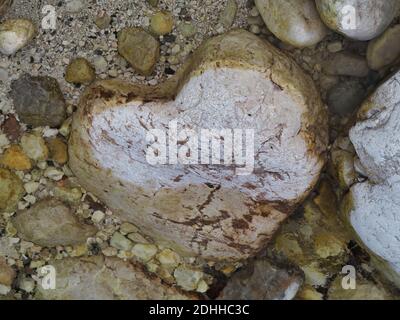 Una vista dall'alto di una pietra a forma di cuore in acqua Foto Stock
