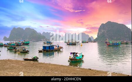 Attracco barca nella baia di ha Long, Vietnam con molte barche da pesca ancorate. Questo è considerato un sito naturale patrimonio dell'umanità Foto Stock