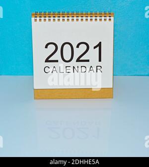 Calendario bianco dell'anno 2021 con sfondo blu su bianco scrivania Foto Stock