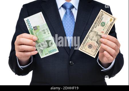 Uomo d'affari che tiene in mano dollari americani e valuta coreana. Foto Stock