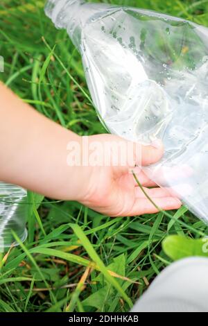 Usato sacchetto di plastica vuoto nelle mani di una bambina durante la pulizia del parco da detriti Foto Stock