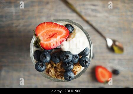 Gelato con fragole e mirtilli in un bicchiere alto Foto Stock