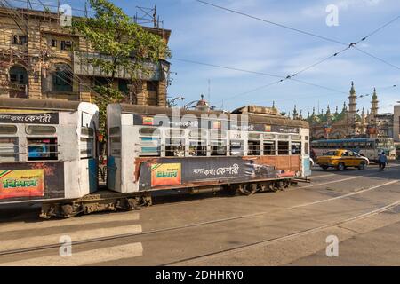 Kolkata tram sulla strada della città con vecchi edifici storici nella zona di Esplanade Dharmatala, India Foto Stock