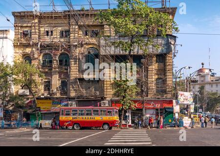 Mezzi di trasporto pubblico sulla strada della città indiana con il vecchio patrimonio Edifici a Esplanade Kolkata Foto Stock