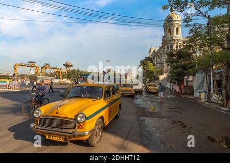 Stand taxi con vista della strada cittadina vicino al patrimonio coloniale edificio metropolitano presso l'area Esplanade di Kolkata, India. Foto Stock