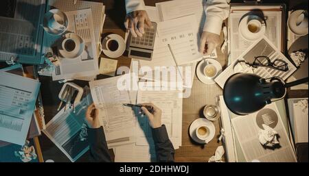 Gli uomini d'affari che lavorano a tarda notte in ufficio, le scadenze e il concetto di lavoro straordinario Foto Stock