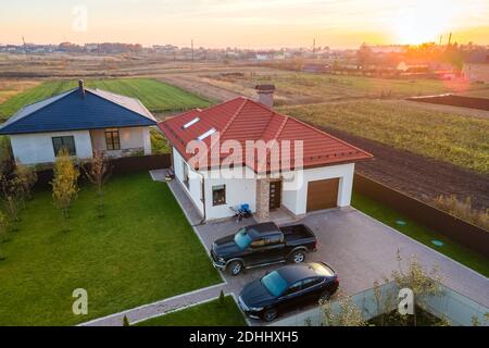 Vista aerea di una casa privata suburbana con auto parcheggiate nel cortile posteriore. Foto Stock