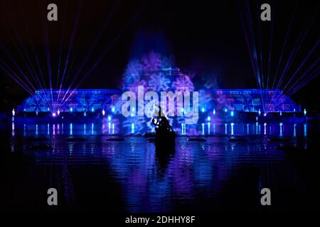 Una vista della 'Palm House Grand finale', che include proiezioni festive che cadono su un enorme schermo d'acqua nel lago durante il Natale a Kew presso i Royal Botanic Gardens a Kew, Londra. Foto Stock