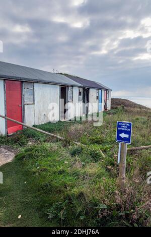 Il percorso costiero deviato e chalet vacanza abbandonato a causa di erosione scogliera, Brighstone Bay, Isola di Wight Foto Stock