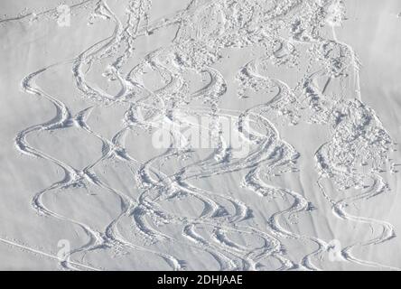 Piste da sci ondulate nella neve profonda sulle piste di montagna innevate. Bianco sfondo sportivo invernale. Foto Stock
