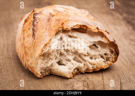 Un pezzo di pane su tavola di legno Foto Stock