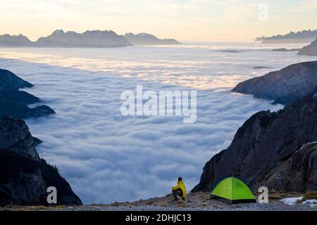 Uomo e tenda sopra le nuvole, Trentino-Alto Adige, Alto Adige in Bolzano, alta Pusteria, Hochpustertal, Dolomiti Sesto, Italia Foto Stock