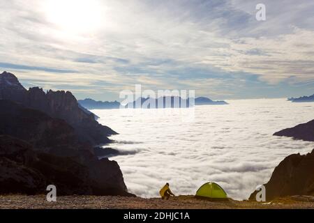 Uomo e tenda sopra le nuvole, Trentino-Alto Adige, Alto Adige in Bolzano, alta Pusteria, Hochpustertal, Dolomiti Sesto, Italia Foto Stock