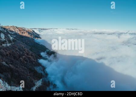 Ghost rotto in alto sulle montagne sopra le onde della nebbia, circondato da gloria. Silhouette su una forte nebbia e raggi del sole, un fenomeno naturale - Foto Stock