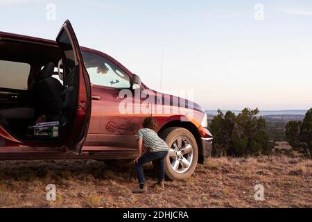 Ragazzo giovane che scrive sul camion del raccoglitore sporco Foto Stock