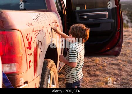 ragazzo giovane che scrive sul camion del raccoglitore sporco Foto Stock