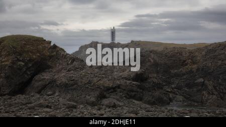 Possenti scogliere di Valdovino e faro di Punta Frouxeira durante una giornata nuvolosa in Galizia, Spagna Foto Stock