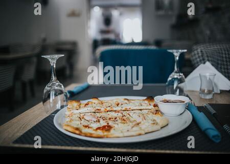 Un pizzico verticale di deliziosa pizza servita con ketchup in un ristorante Foto Stock
