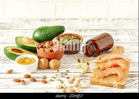 Fonti animali e vegetali di acidi omega-3. Concetto di dieta equilibrata. Assortimento di cibo sano su tavola di legno, Foto Stock