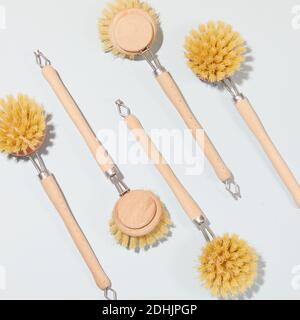 Vista dall'alto della collezione di spazzole eco-compatibili per il lavaggio piatti disposti su sfondo bianco in studio Foto Stock